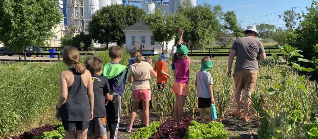 Young kids exploring farming techniques at a Matthew 25 food camp in Cedar Rapids Iowa