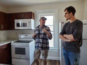 Matthew 25 Neighborhood Building Senior Director, Brenner Myers, talk with Jonny Reinert about the new kitchen built in the upper-level unit.
